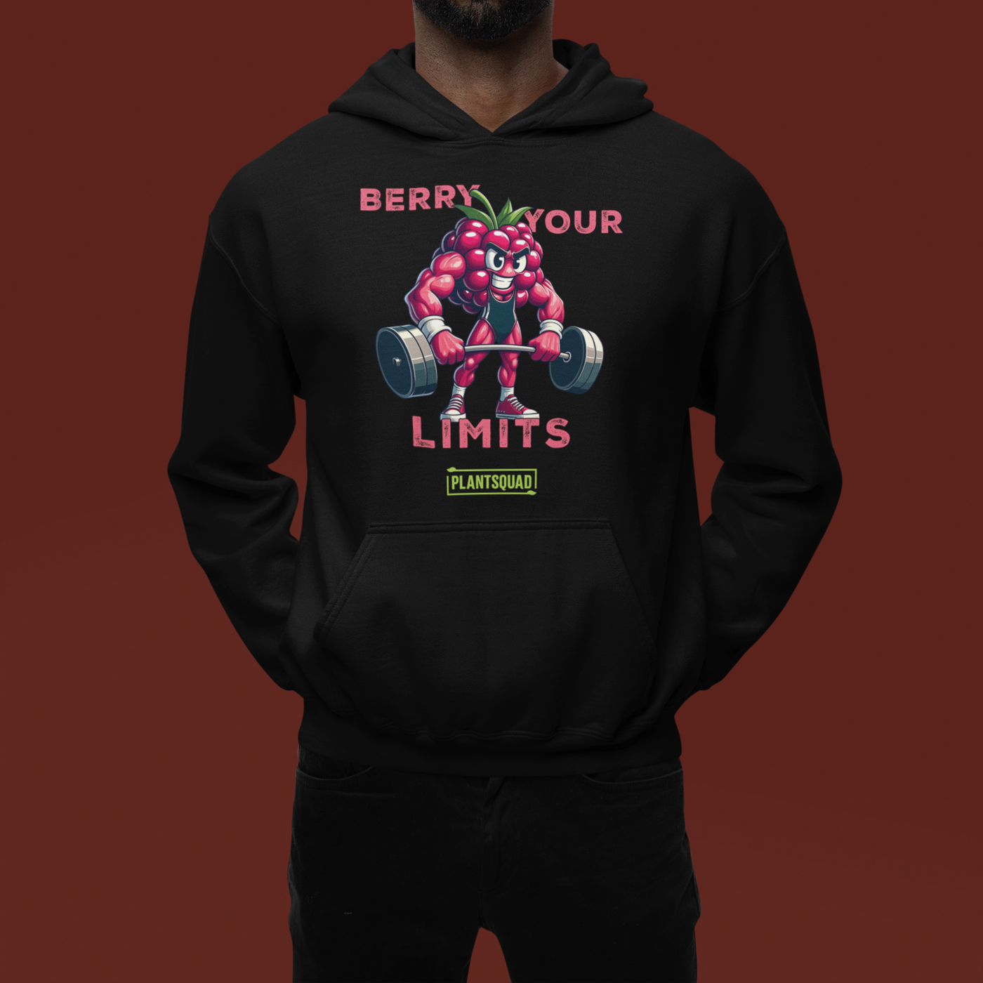 A black hoodie with a printed cartoon image of a muscular strawberry character lifting dumbbells. The text above reads "Berry Your Limits," perfect for those embracing a vegan gym wear style, and "Plantsquad" is written below the character. Introducing the Plantsquad Raspberry "Berry Your Limits" - Unisex Hoodie.