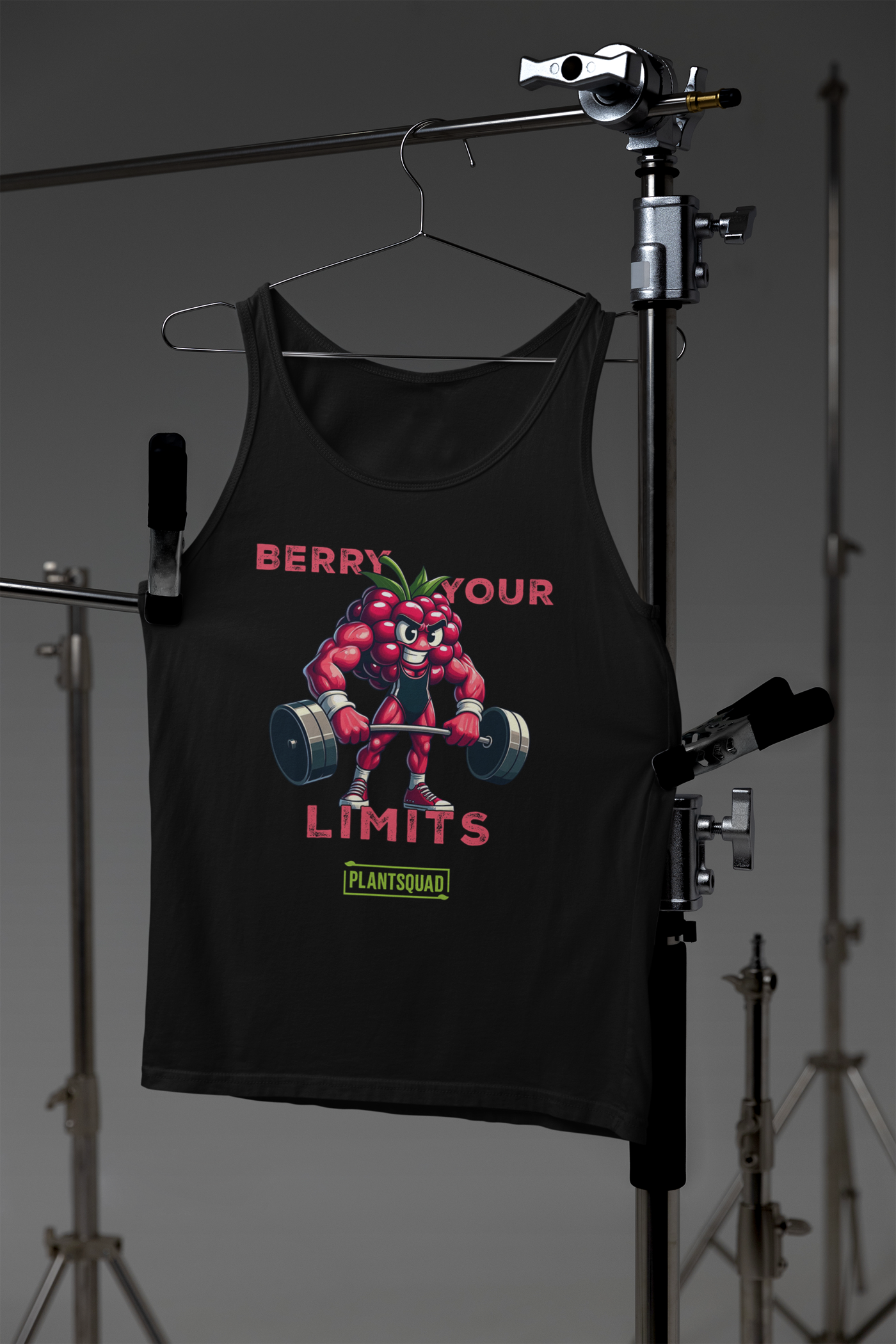 A Plantsquad Raspberry "Berry Your Limits" - Unisex Tank Top features a muscly raspberry cartoon lifting a barbell, embodying the plant-based lifestyle. The text "BERRY YOUR LIMITS" appears above the image, and "PLANTSQUAD" is displayed in a green box below the character.