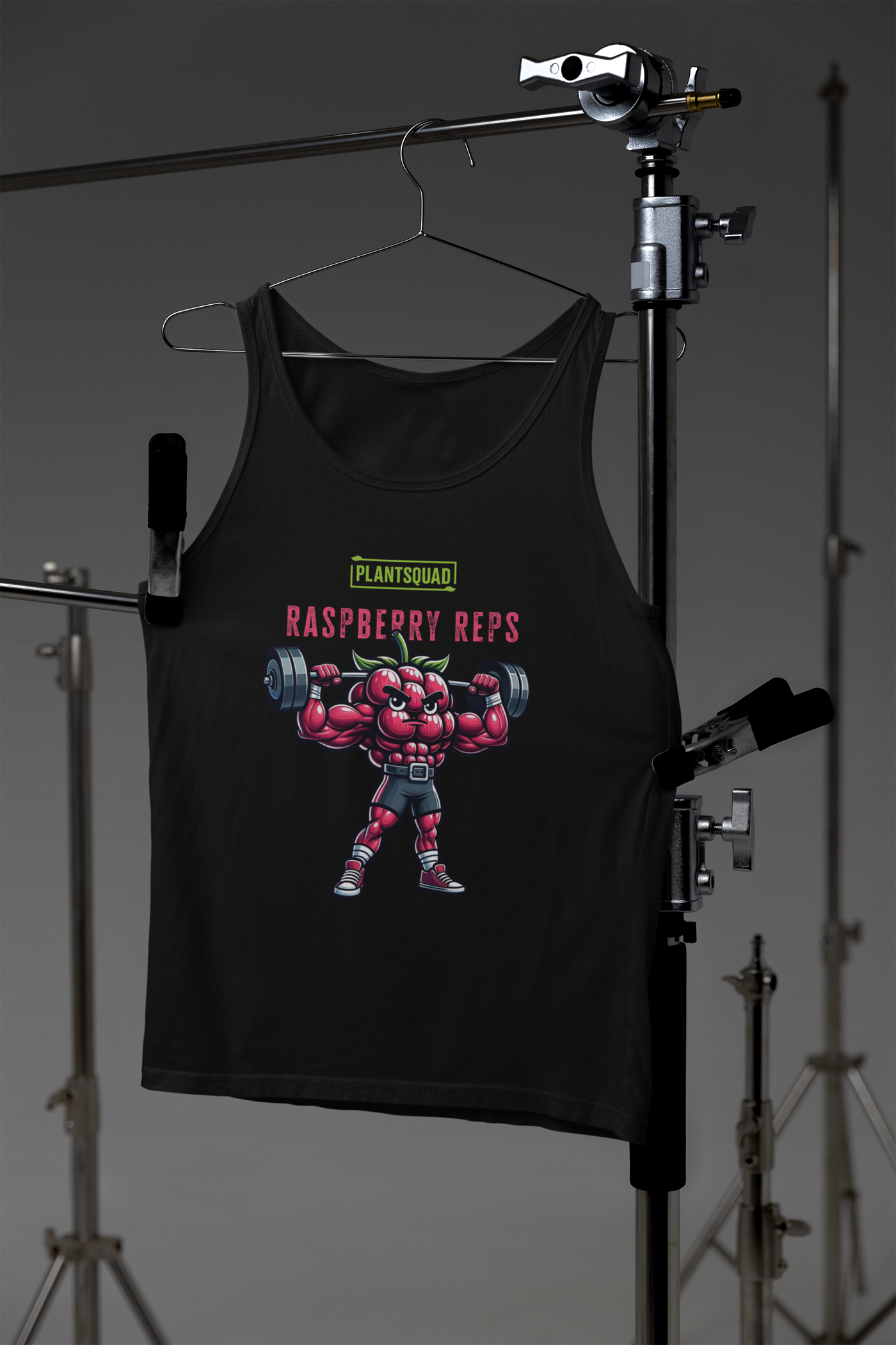 A black Plantsquad Raspberry "Raspberry Reps" - Unisex Tank Top featuring a muscly raspberry character lifting barbells. The character has muscular arms and legs, and is wearing shorts. Above it are the words "PLANTSQUAD" and "Raspberry Reps" in stylized fonts, perfect for fans of vegan fitness apparel.