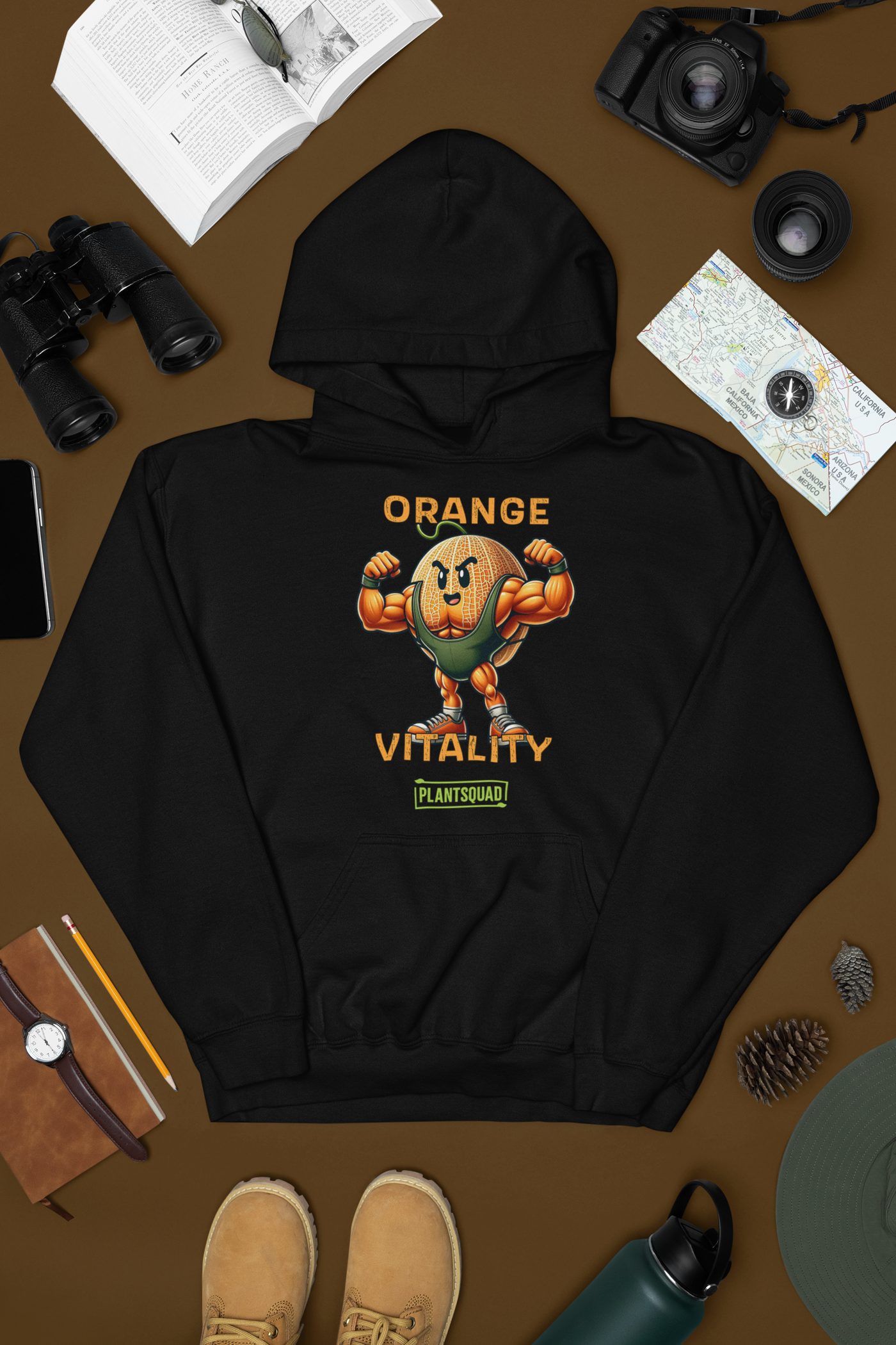 A black hooded sweatshirt boasts a muscular, cartoon orange with a fierce expression, flexing its arms. Above the orange, text reads "ORANGE VITALITY." Below it, a logo with the text "PLANTSQUAD" celebrates the vegan lifestyle. The product is called Plantsquad Rockmelon "Orange Vitality"" - Unisex Hoodie.