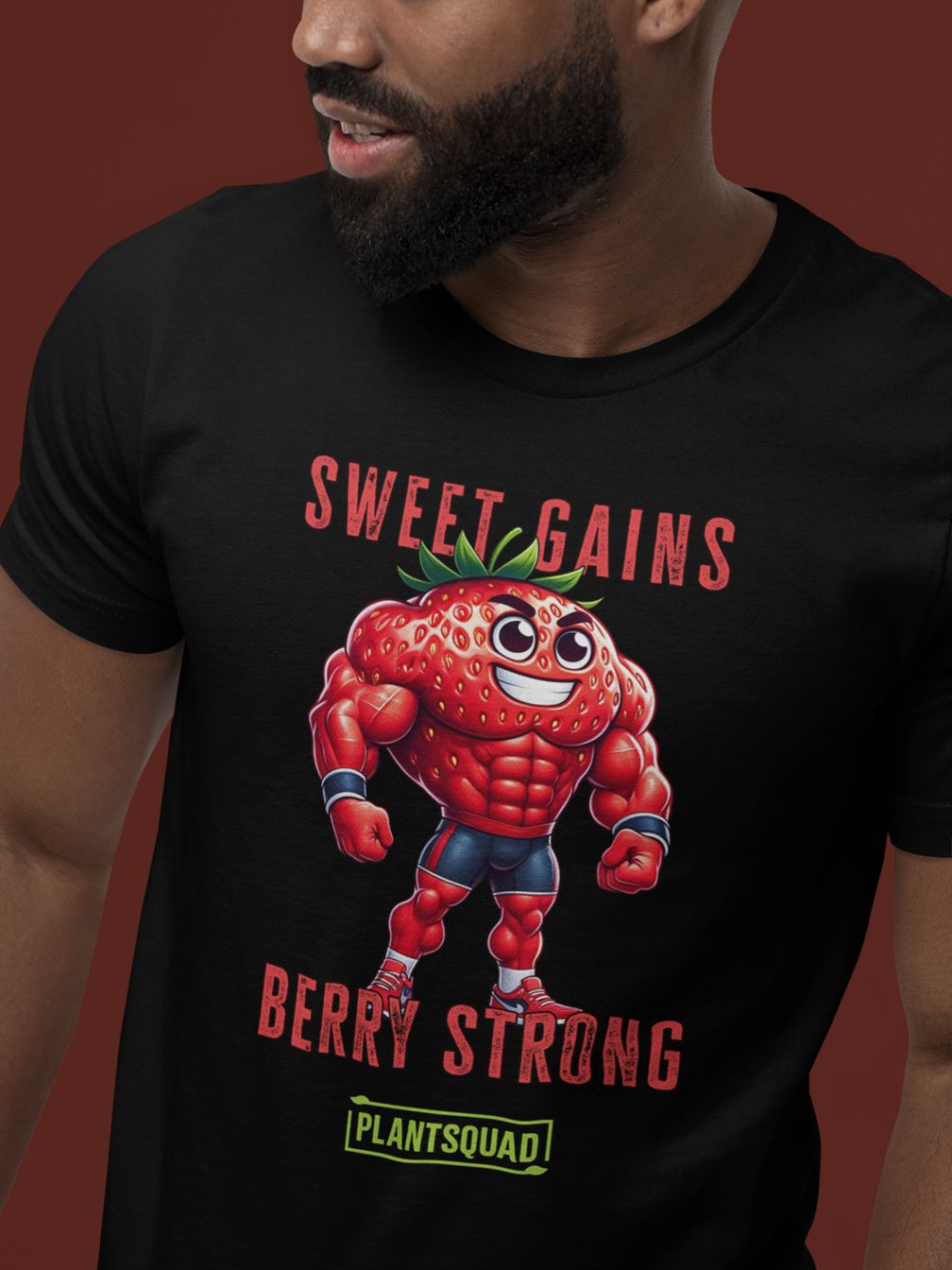 A black fitness T-shirt featuring a cartoon muscular strawberry in a superhero pose. Above the strawberry, the text reads "SWEET GAINS," and below it, "BERRY STRONG." Perfect for those embracing a vegan lifestyle, it sports a green logo with the word "PLANTSQUAD" at the bottom is called **Plantsquad Strawberry "Sweet Gains Berry Strong" - Unisex T-Shirt**.