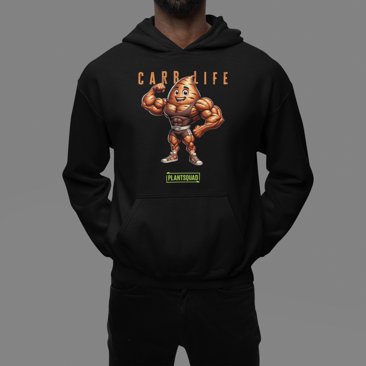 A Plantsquad Sweet Potato "Carb Life" - Unisex Hoodie featuring a cartoon image of a muscular vegetable with a smiling face. Above the image is the text "CARB LIFE" in orange letters, and below it is a green and white logo that reads "PLANTSQUAD." Made from cozy fabric, it's perfect for those embracing a vegan lifestyle.