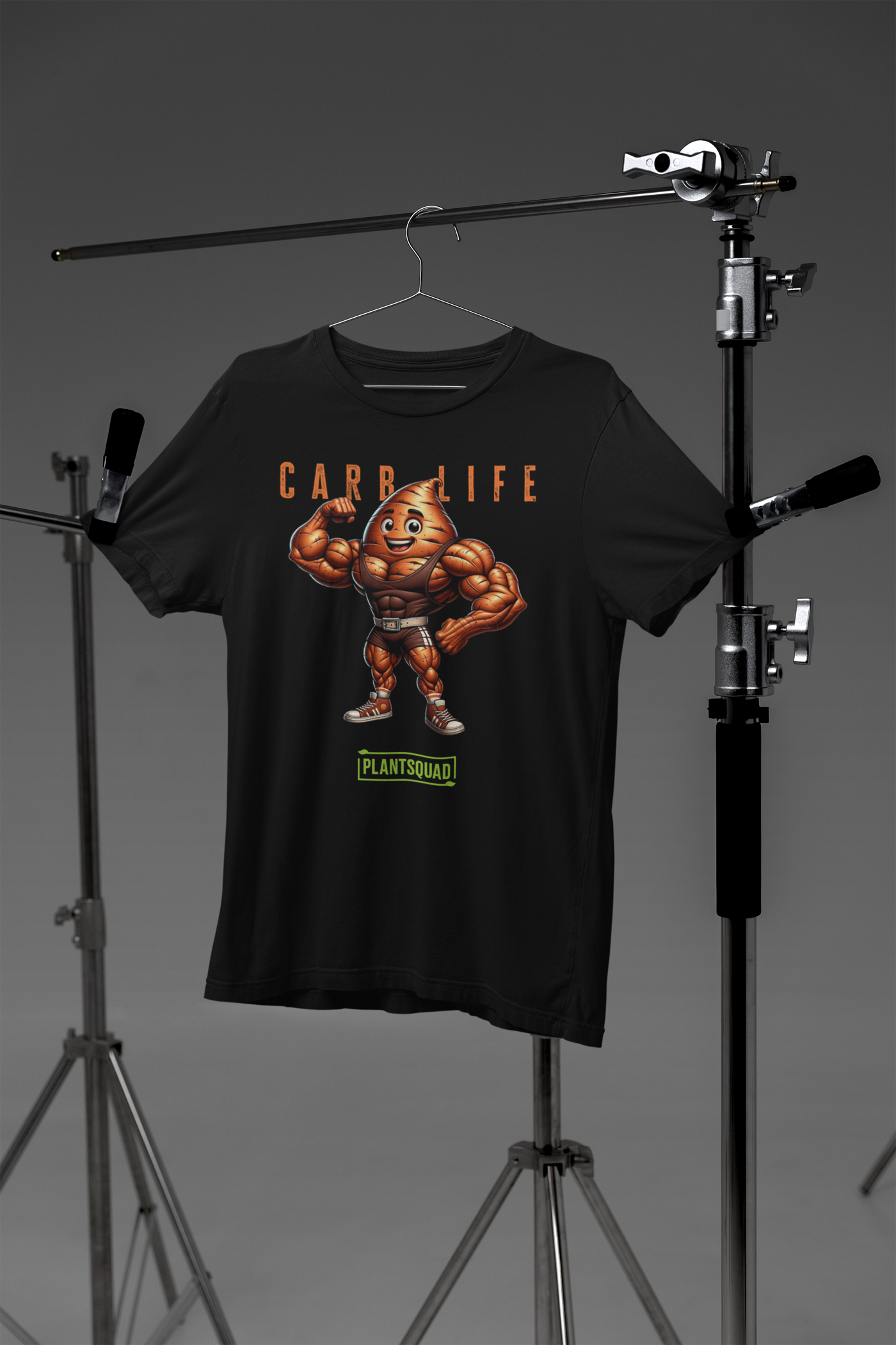 Plantsquad Sweet Potato "Carb Life" - Unisex T-Shirt featuring a muscular, flexing potato character with a smiley face. Above the character, text reads "CARB LIFE" in bold letters. Below the character, the word "PLANTSQUAD" appears in a green banner. Perfect for those embracing a plant based lifestyle and looking for unique fitness clothing.