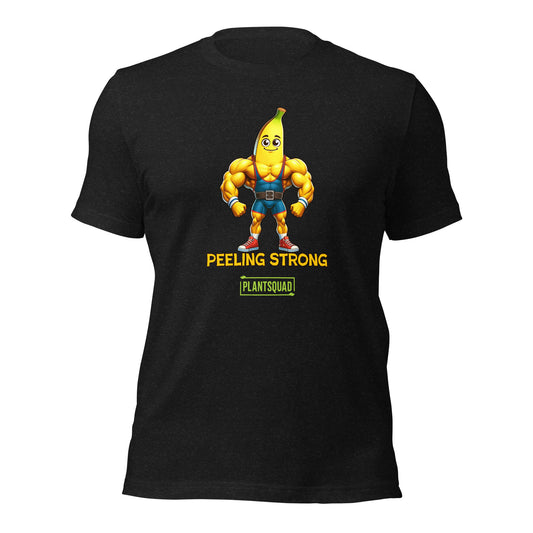 A Plantsquad Banana "Peeling Strong" - Unisex T-Shirt featuring a muscular cartoon banana character flexing its biceps. The character is wearing blue shorts and orange shoes. Below the character, the text reads "PEELING STRONG" with a small green banner underneath proudly displaying "PLANTSQUAD.