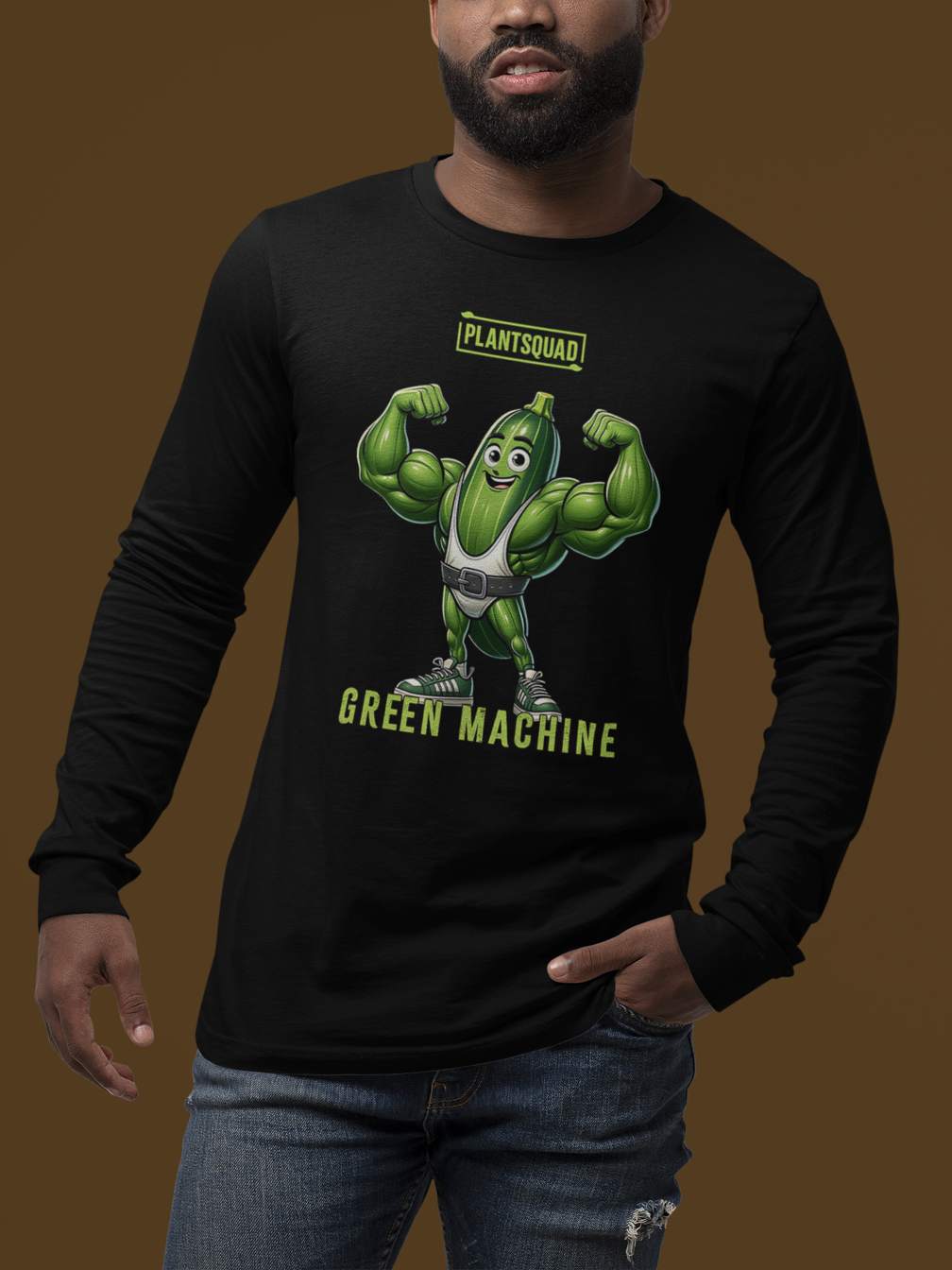 Black long-sleeve shirt displaying a cartoonish green muscular vegetable character flexing its muscles. The text "PLANTSQUAD" is at the top, with "GREEN MACHINE" below the character. Perfect for fitness enthusiasts embracing a vegan lifestyle, this Plantsquad Zucchini "Green Machine" - Unisex Long Sleeve T-Shirt combines humor and health.